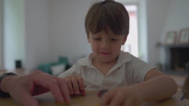 小男孩打开礼物后从桌上抓起玩具车 小孩玩汽车玩具 — 图库视频影像
