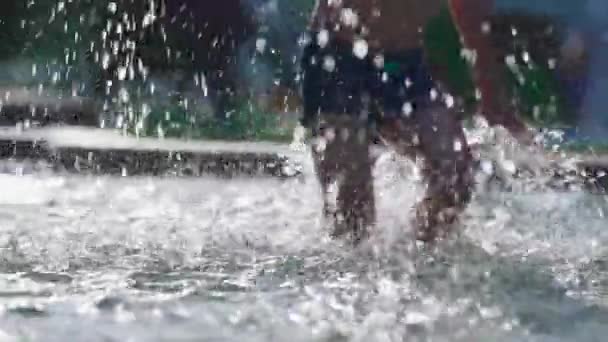 小さな男の子は夏の日の活動中に公共のプールでリフレッシュします 120Fpsのスローモーションで水を飛ばすプールサイドで歩く子供 — ストック動画