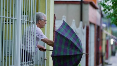 Yaşlı adam yağmur yağarken eve gelir, kapıyı açar ve şemsiyeyi kapatır. Sokak kaldırımında yürüyen son sınıf öğrencisi konutuna varır.