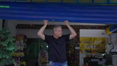 Kaldırımdaki Petshop 'un sahibi garaj önünü kapatıyor.