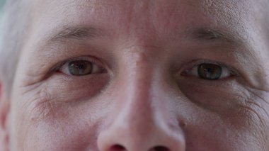Makro, 40 'lı yaşlarda kameraya bakan orta yaşlı bir adam. Bir insanın tarafsız bakışları detaylarla yüzleşir