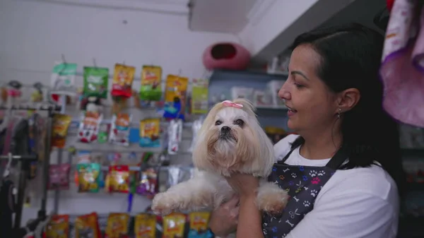 Happy Pet Shop female owner giving Dog back to client after grooming service