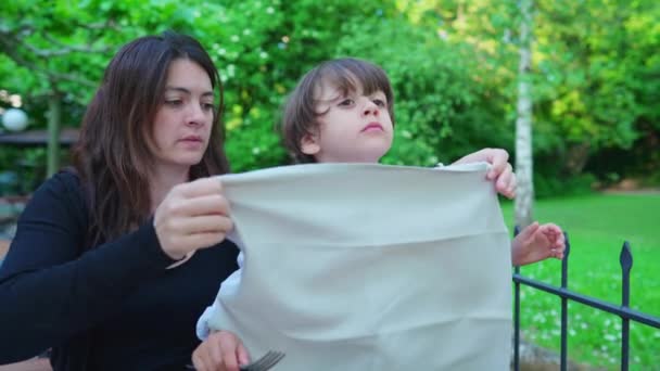 Μητέρα Βάζει Χαρτοπετσέτα Στο Κολάρο Του Παιδιού Για Προστατεύει Ρούχα — Αρχείο Βίντεο