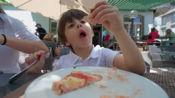 小男孩在餐馆吃比萨饼 小孩午餐吃碳水化合物 — 图库视频影像