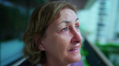 Düşüncelere dalmış, gülümseyen, düşüncelere dalmış son sınıf kadınına bakıyorum.