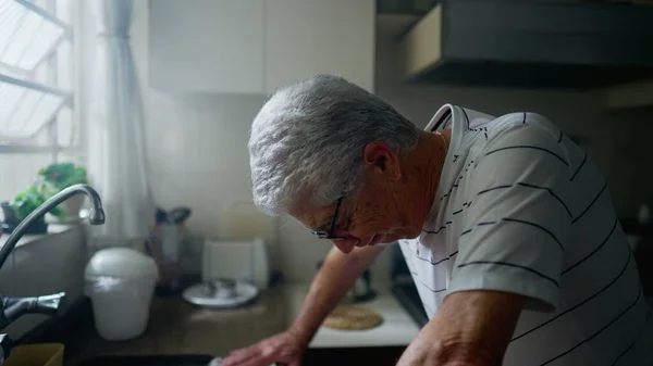 一个成熟的男人站在厨房柜台边 与年老和遗憾作斗争 忧心忡忡的资深男性低头凝视着冰冷的身躯 — 图库照片