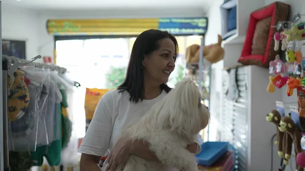 Pet Shop Shopping, Woman with Small Dog Examining Store Items