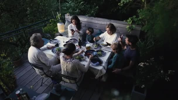 食事テーブルに座った候補者の家族は 食べ物を食べる 本格的な両親と子供たちが集まって夕食をとりました — ストック動画