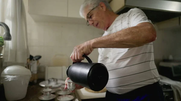 老人站在厨房里 端着热饮给妻子 享用着热饮咖啡 这是家居生活的惯例 — 图库照片