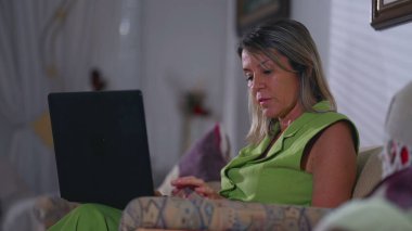 Akşamları evdeki koltukta oturan dizüstü bilgisayarda daktilo yazan son sınıf öğrencisi bir kadın. Yaşlı beyaz kadın modern teknolojiyle meşgul, e-posta yazıyor.