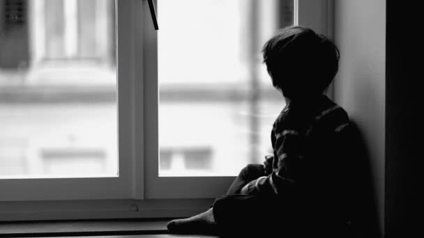 メランコリックの子供は深い精神的な反射の中でアパートの窓から眺めます モノクロマティック 黒と白のシーンで悲しいペンギンボーイ — ストック動画