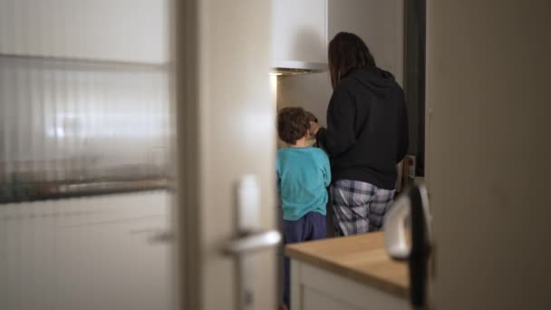 식사를 준비하는 어머니와 아들의 순간에서 아이가 관찰하고 관심을 원하는 문에서 — 비디오