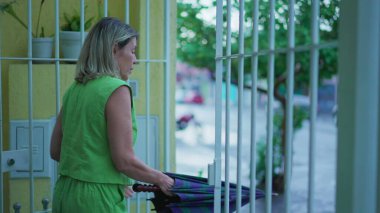 Evi terk eden, şemsiyesini açan ve yağmur yağarken şehir caddesine çıkan biri. Yağmurlu bir öğleden sonra yorgun düşerken kapıyı açık bırakan bir kadın.