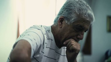 Derin akli dengesi yerinde gri saçlı bunalımlı yaşlı bir adam kasvetli bir odada kasvetli bir atmosferde oturuyor.