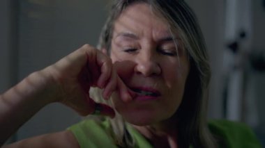 Derin zihinsel yansıma içinde pencere kenarında oturan düşünceli olgun bir kadının yakın plan yüzü. Düşünceli orta yaşlı insan kararını düşünüyor.