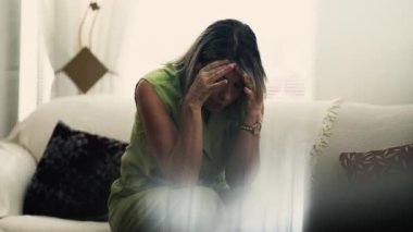 Depresyondaki olgun kadın evde yalnız başına acı çekiyor pişmanlık ve endişelerle boğuşuyor. Açık yürekli orta yaşlı insan evde koltukta oturmuş hayal kırıklığı ve endişe hissediyor.