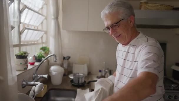 Аутентичная Домашняя Сцена Счастливого Пожилого Человека Сушки Посуды Раковине Кухни — стоковое видео