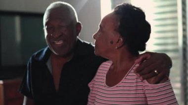 Mutlu Afrikalı Amerikalı çift yatak odasında romantik anlar yaşıyor, koca yaşlı karısına sarılıyor.