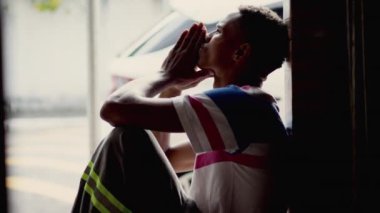 Depressed man sitting on floor. Sad unhappy person holding his forehead suffering from mental illness