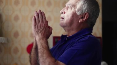 Dua eden sadık, yaşlı bir adam meditasyonda gözleri kapalı zor zamanlarda umutla ve inançla dua ediyor. Tanrı 'ya dua eden kıdemli kişinin yakın plan yüzü.