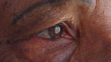 Yaşlı bir siyahi adamın gözünün Macro yakın çekimi, Afrikalı yaşlı bir Amerikalının vizyonunun detaylı görüntüsü