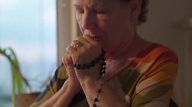 Umut dolu son sınıf öğrencisi evde dua ederek dua ediyor. Dua eden Katolik yaşlı büyükanne.