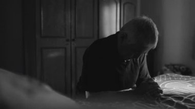 PRAYER 'da yatağının yanında haç işareti yapan yaşlı bir adamın dramatik sahnesi. Ruhsal İbadet Katolik rutini