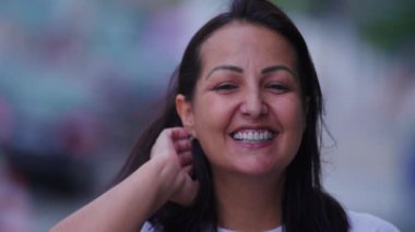Dışarıdaki kameraya gülümseyen orta yaşlı neşeli esmer kadın. Hakiki mutlu kişi.