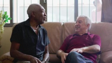 Evdeki Koltukta oturan iki kıdemli arkadaşın otantik etkileşimi, Irklar Arası Yaşlı Arkadaşların Gülmesi, Gülümsemesi ve Muhabbet Etmesi