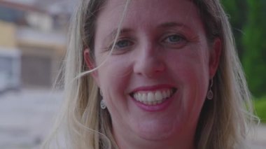 Kafkasyalı 40 'lı yaşlarda, kameraya bakıp gülümseyen bir kadının portresi.