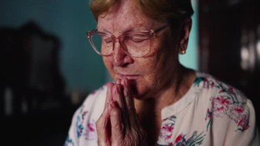 Dua eden yaşlı bir kadın, umutlu ve inançlı.