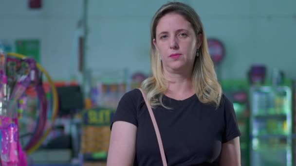 Серьёзная Женщина Покупатель Корзине Покупками Смотрит Камеру Стоящую Внутри Супермаркета — стоковое видео