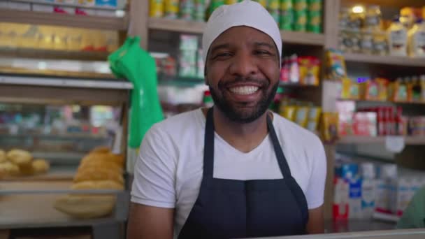 一个快乐的巴西黑人年轻雇员的画像 在一家传统餐厅的柜台后面微笑着 戴着围裙和帽子 工作人员职业概念 — 图库视频影像