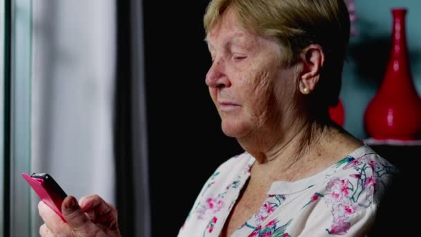 Пожилая Женщина Читает Сообщения Телефону Себя Дома Изображая Современные Технологии — стоковое видео