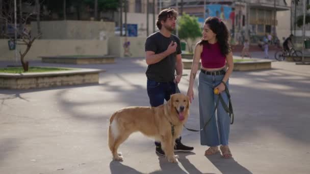 坎德夫妇和他们的狗在城外的城市 千禧一代带着他们纯洁的金毛猎犬站在外面 — 图库视频影像