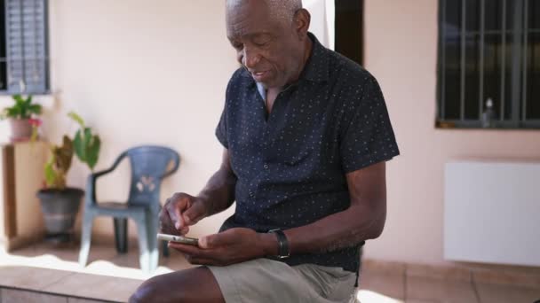 Zwykły Staruszek Używa Telefonu Podwórku Afroamerykanin Starszy Człowiek Zaangażowany Nowoczesną — Wideo stockowe