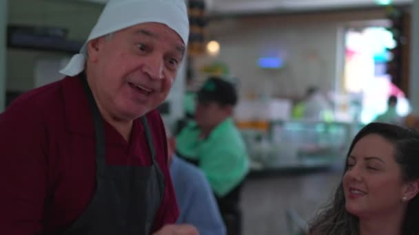 Neşeli Yaşlı Garson Restorandaki Müşteri Grubu Ndan Sipariş Alıyor — Stok video