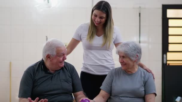 Älteres Paar Mit Junger Trainerin Physiotherapie Setting Posiert Für Ein — Stockvideo