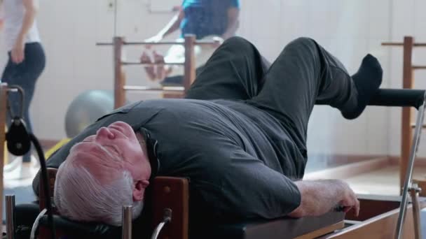 Elderly Man Using Pilates Machine Strengthen Body Physiotherapy Studio Senior — Stock Video