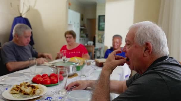 ランチにシニアの友達が集まり 食卓から食事を奪い お年寄りの人々が食事の上で再会 — ストック動画