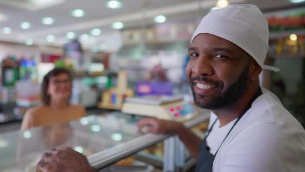 一位传统餐厅的巴西黑人员工在柜台后面把头转向摄像机 一个快乐的黑人员工看着镜头笑着 — 图库视频影像