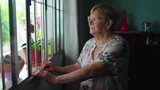 Созерцательная Пожилая Женщина Стоящая Окна Дома Задумчивое Выражение Лица Старше — стоковое видео