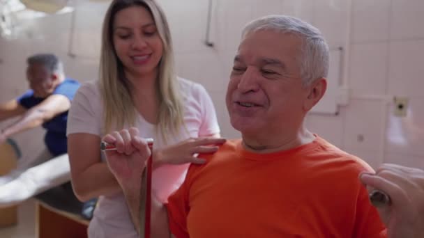 Yaşlı Adamın Kadın Koçun Yardımıyla Vücut Egzersizi Yaptığı Pilates Seansı — Stok video