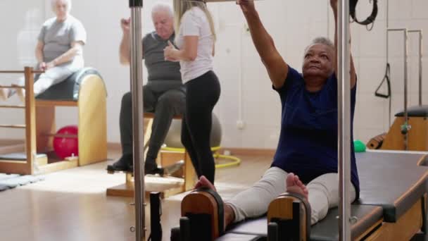 一位黑人老年妇女穿着普拉提机运动 享受老年体育生活 实力和灵活性 — 图库视频影像
