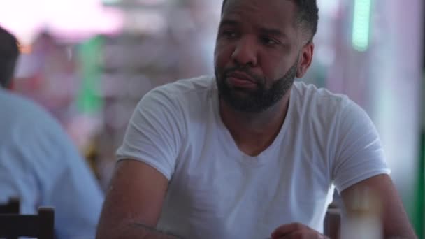 Düşünceli Bir Siyah Adam Restoranda Oturmuş Düşünceli Bir Bakışla Bekliyor — Stok video