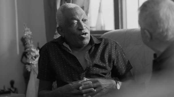 非裔美国人老年人在单色黑白沙发上与朋友进行真诚的对话 — 图库视频影像
