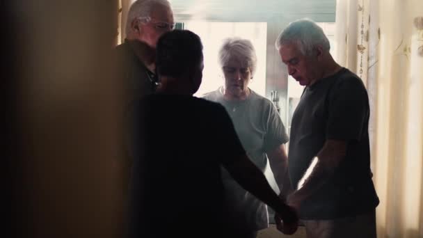 自宅で祈りに手を差し伸べている宗教家 ホープとFaithを持って目を閉じた高齢者のグループ — ストック動画