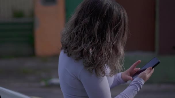 Городская Женщина Использует Мобильный Телефон Опираясь Автомобильную Шапочку Отслеживая Выстрел — стоковое видео