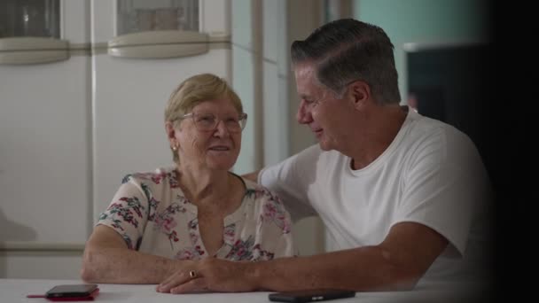 大儿子和年老的母亲在家里厨房里交流 中年男子照顾老年父母的犬牙老年生活方式 — 图库视频影像