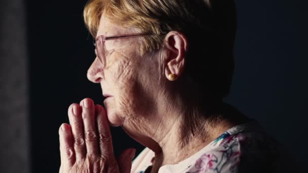 希望与信仰的概念 老年妇女站在窗边 向上帝祈祷 并在十字架上签名 作为一位天主教老年老人深深奉献 — 图库视频影像